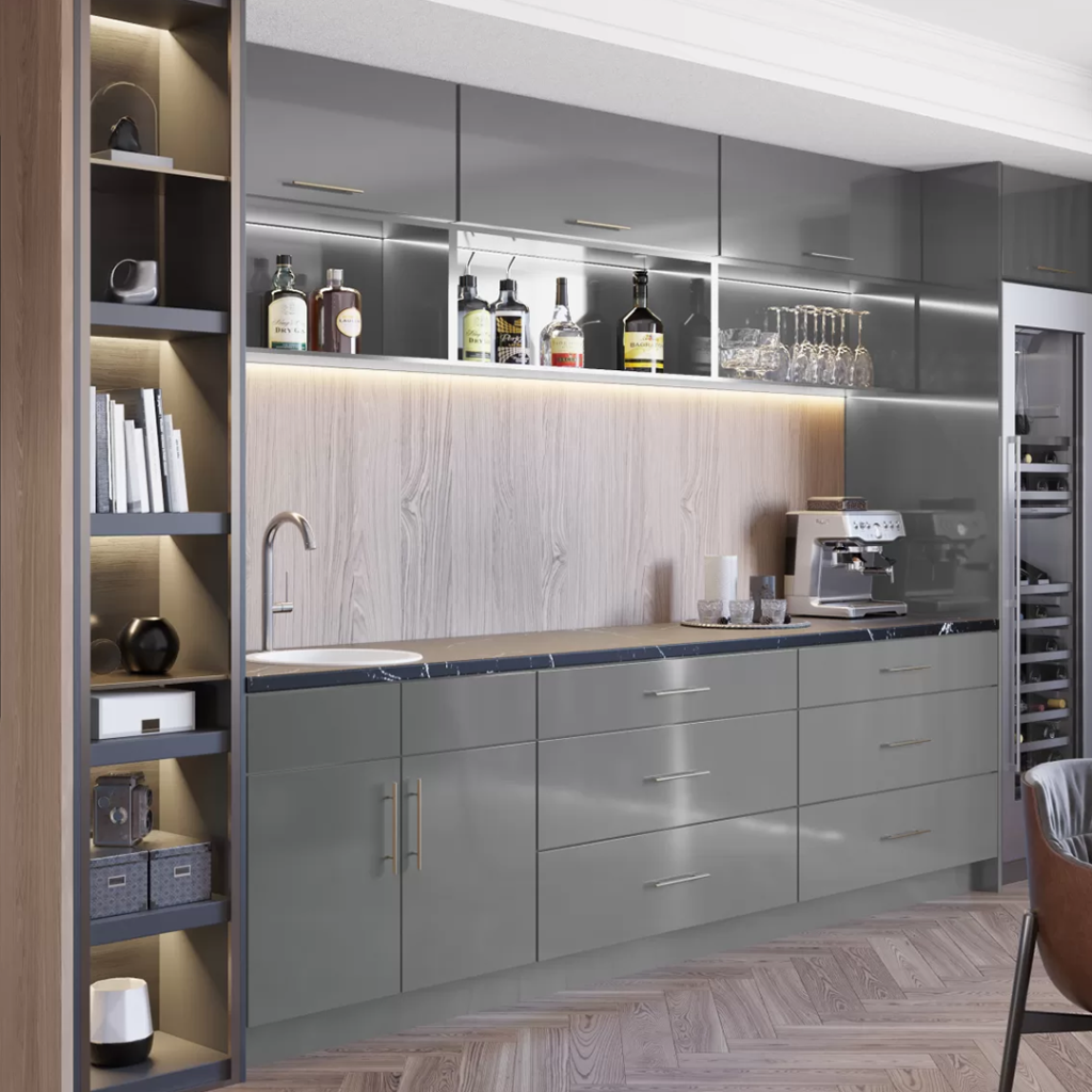 A modern kitchen with sleek gray cabinetry, wood accents, and a well-lit bar area displaying liquor bottles and glassware.