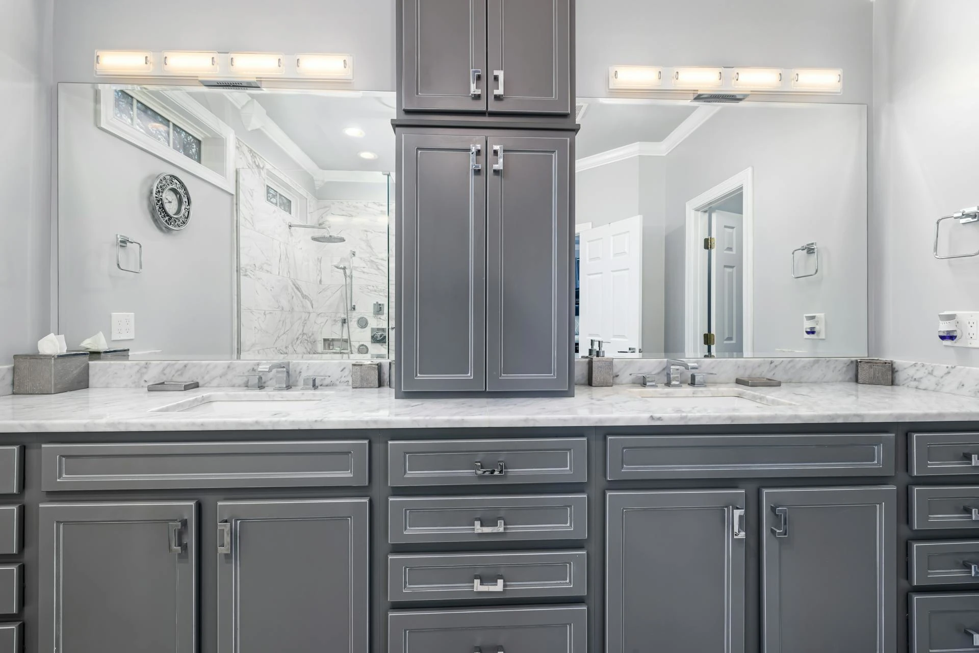 A modern bathroom featuring gray cabinets and elegant marble countertops, showcasing a sleek and sophisticated design.