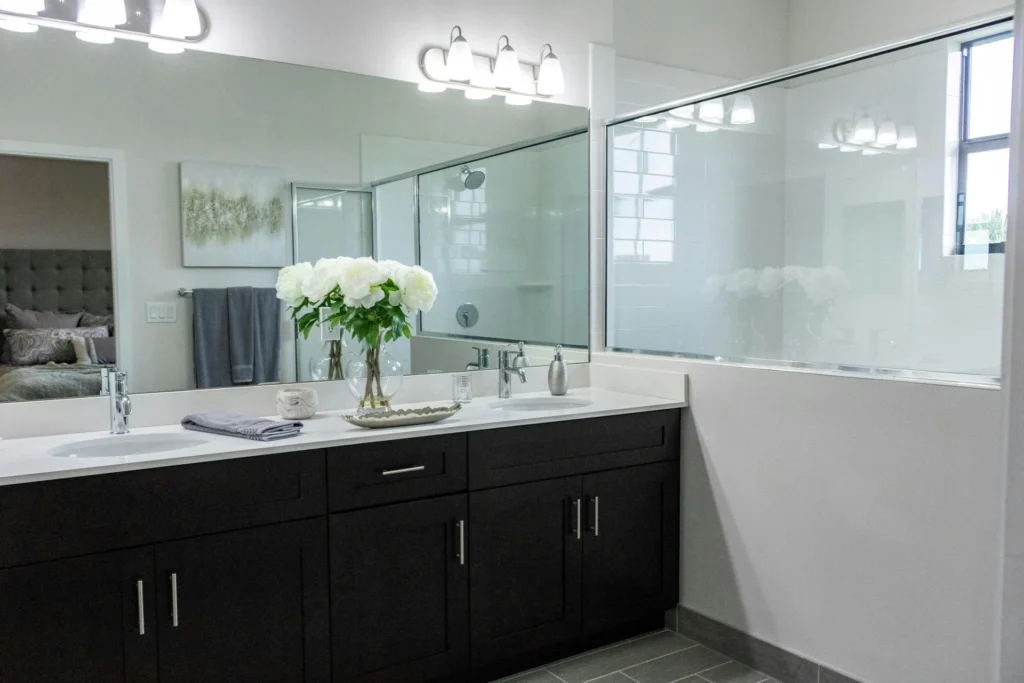 A modern bathroom featuring a double sink and a spacious shower area, designed for comfort and functionality.