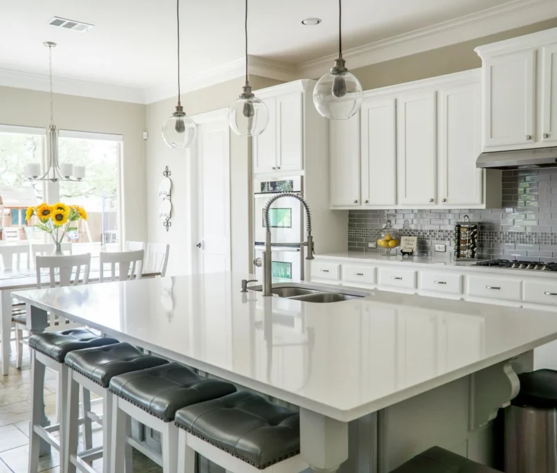 A modern kitchen featuring a central island and a cozy dining area, designed for functionality and style.