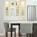 A cozy kitchen featuring a wooden table surrounded by chairs, creating an inviting dining space.