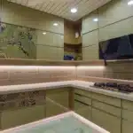 A modern kitchen featuring a wall of cabinets and an illuminated wall of lights, creating a bright and functional space.