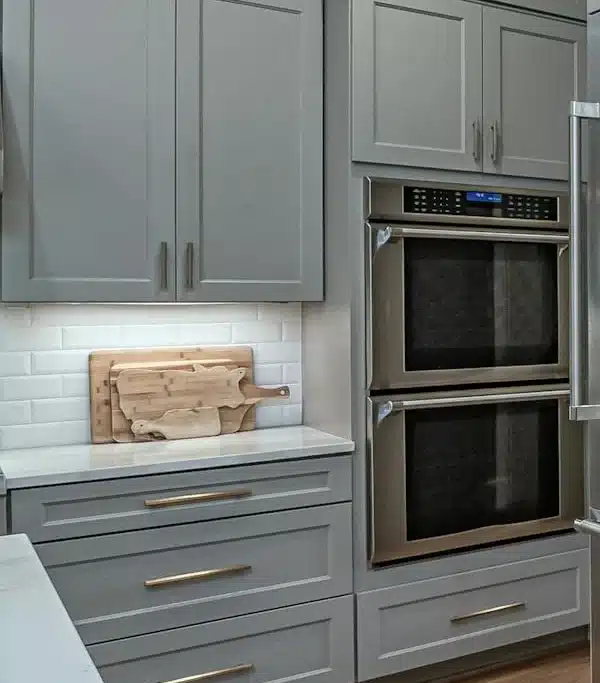 A modern kitchen featuring stainless steel appliances and sleek gray cabinets, showcasing a contemporary design.