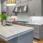 A modern kitchen featuring sleek gray cabinets and a stylish marble island, creating an elegant and functional space.