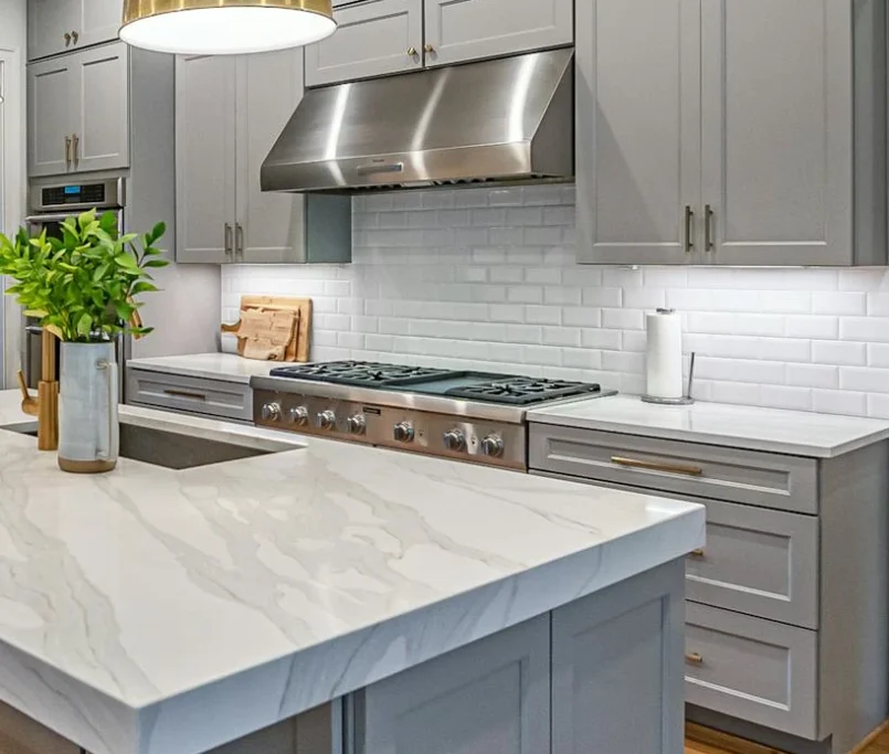 A modern kitchen featuring sleek gray cabinets and a stylish marble island, creating an elegant and functional space.