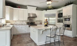 A spacious kitchen featuring white cabinets and a central island, designed for functionality and style.