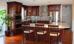 A modern kitchen featuring a central island and elegant wooden flooring, creating a warm and inviting atmosphere.