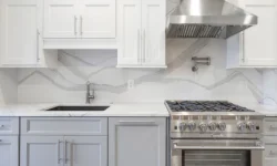 A modern kitchen featuring white cabinets and sleek stainless steel appliances, creating a bright and contemporary atmosphere.