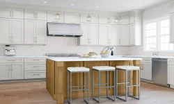 A modern kitchen featuring white cabinets and warm wooden floors, creating a bright and inviting atmosphere.