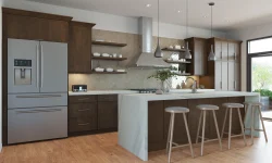 A modern kitchen featuring a spacious island and a sleek refrigerator, designed for functionality and style.